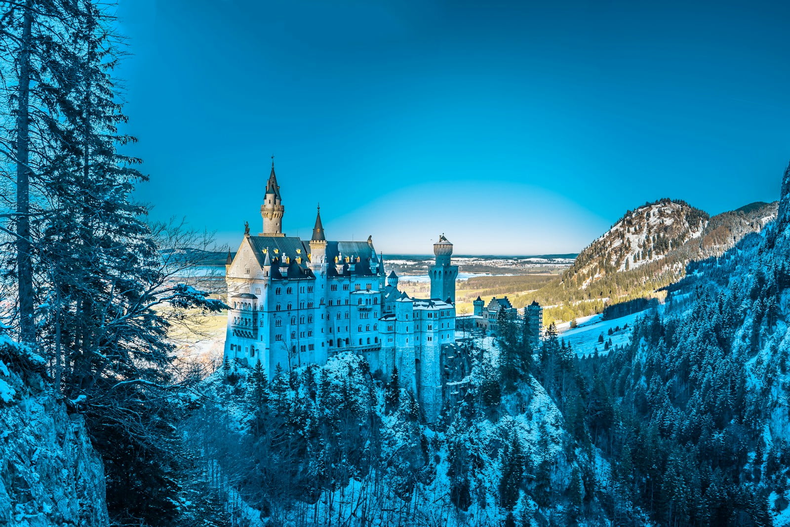 white castle on snow mountain under clear blue sky